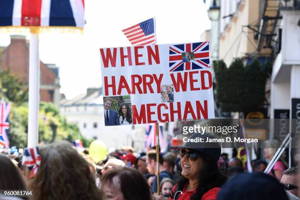 Royal fan holds a sign before the Duke and Duchess of Sussex left in the Ascot Landau carriage during the procession after getting married at St...