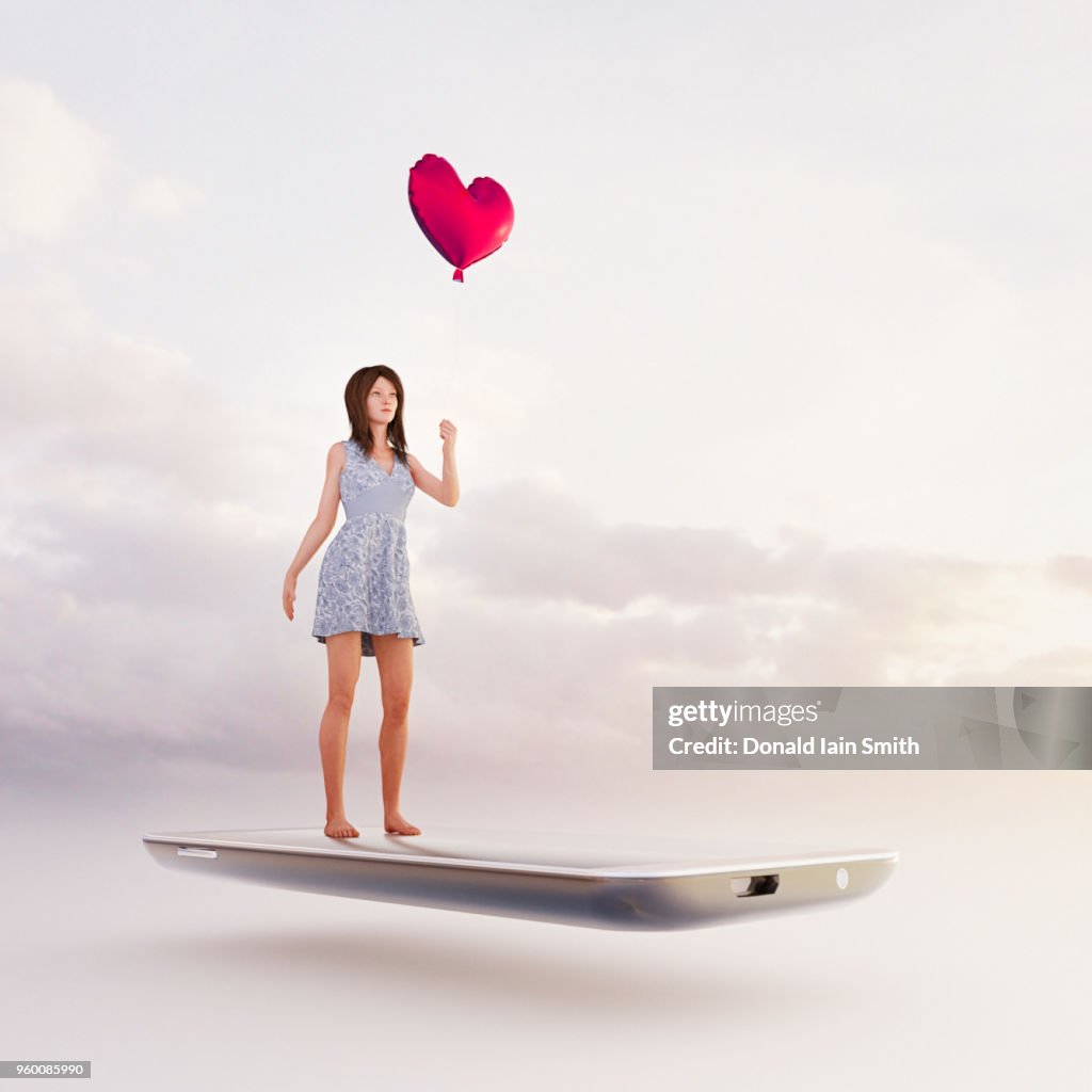 Online dating concept: searching for a partner holding a heart shape red balloon standing on mobile phone