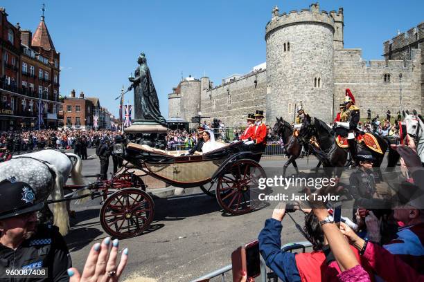 Prince Harry, Duke of Sussex and the Duchess of Sussex ride in the Ascot Landau carriage during the procession after getting married at St George's...
