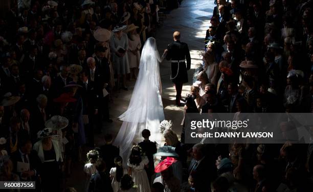 Britain's Prince Harry, Duke of Sussex and Britain's Meghan Markle, Duchess of Sussex, walk away from the High Altar toward the West Door at the end...