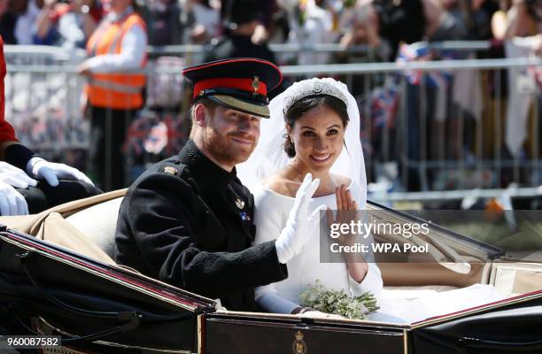Prince Harry, Duke of Sussex and Meghan, Duchess of Sussex wave from the Ascot Landau Carriage during their carriage procession on Castle Hill...