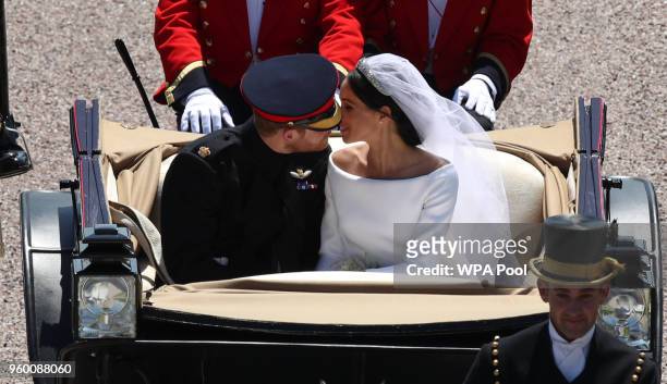 Prince Harry, Duke of Sussex and the Duchess of Sussex kiss in the Ascot Landau Carriage as their carriage procession rides along the Long Walk, on...