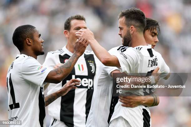 Miralem Pjanic of Juventus celebrates the goal of 2-0 with teammates during the serie A match between Juventus and Hellas Verona FC at Allianz...