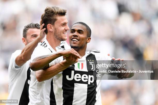 Daniele Rugani of Juventus celebrates the goal of 1-0 with teammates Andrea Barzagli and Douglas Costa during the serie A match between Juventus and...