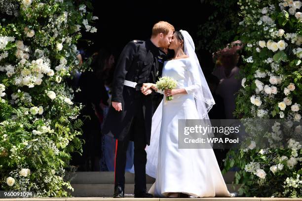 Britain's Prince Harry, Duke of Sussex kisses his wife Meghan, Duchess of Sussex as they leave from the West Door of St George's Chapel, Windsor...