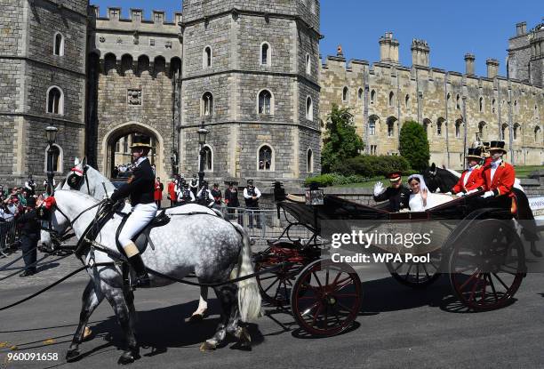 Prince Harry, Duke of Sussex and Meghan, Duchess of Sussex wave from the Ascot Landau Carriage during their carriage procession on Castle Hill...