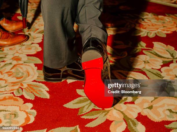 An attendee displays the red sole of a Christian Louboutin shoe during a royal wedding viewing party at the Plaza Hotel in New York, U.S., on...