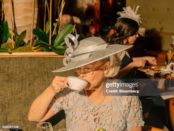 An attendee drinks breakfast tea during a royal wedding viewing party at the Plaza Hotel in New York, U.S., on Saturday, May 19, 2018. Prince Harry,...