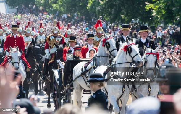 Prince Harry, Duke of Sussex and Meghan, Duchess of Sussex ride in the Ascot Landau carriage during the procession after getting married at St...