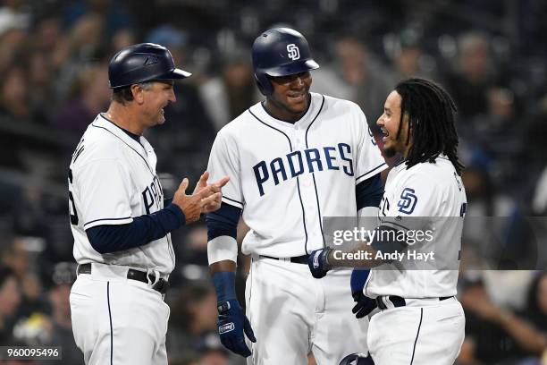 Glenn Hoffman, Franchy Cordero and Freddy Galvis of the San Diego Padres talk at third base during a pitching change during the game against the...