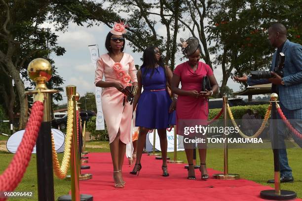 Kenyans walk on the red carpet as they arrive to watch a live screening of the wedding ceremony of Britain's Prince Harry and US actress Meghan...