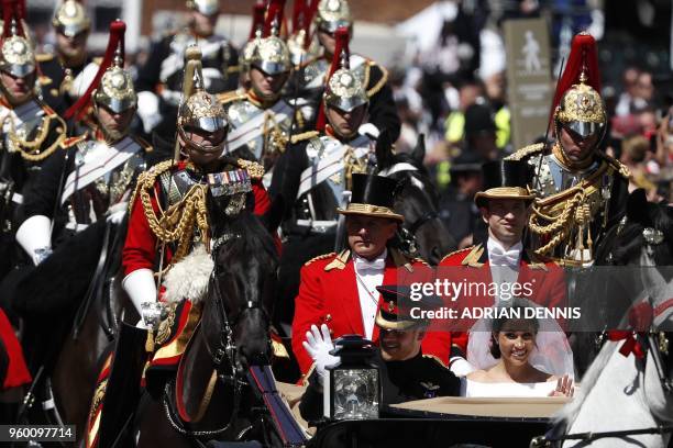 Britain's Prince Harry, Duke of Sussex and his wife Meghan, Duchess of Sussex travel in the Ascot Landau Carriage during their carriage procession on...