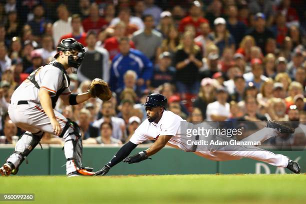 Jackie Bradley Jr. #19 of the Boston Red Sox slides safely past the tag of Andrew Susac of the Baltimore Orioles in the fifth inning of a game at...