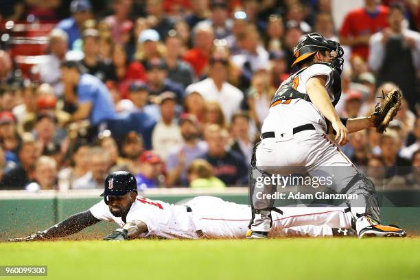 Jackie Bradley Jr. #19 of the Boston Red Sox slides safely past the tag of Andrew Susac of the Baltimore Orioles in the fifth inning of a game at...