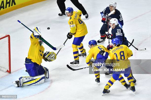 Sweden's goalie Anders Nilsson , Hampus Lindholm , Adam Larsson and Dennis Everberg vie next to the net during the semifinal match Sweden vs USA of...
