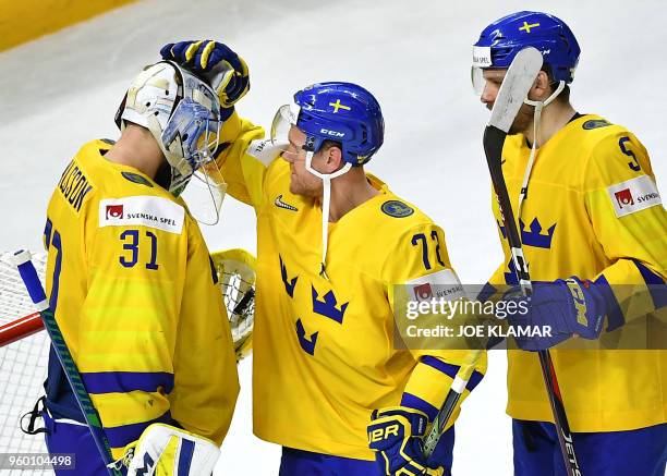 Sweden's goalie Anders Nilsson, Sweden's Patric Hornqvist and Sweden's Mikael Wikstrand celebrate after winning the semifinal match Sweden vs USA of...