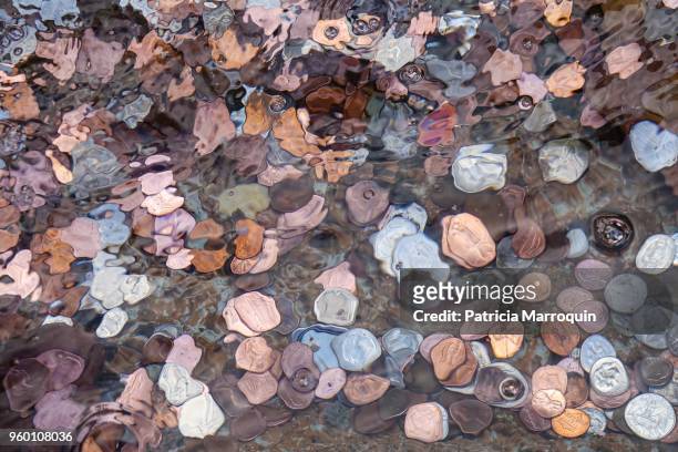 coins in a wishing well - coin fountain stock pictures, royalty-free photos & images