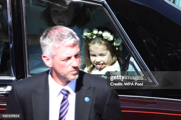 Princess Charlotte waves to the crowd as she rides in a car to the wedding of Prince Harry and Meghan Markle at St George's Chapel in Windsor Castle...