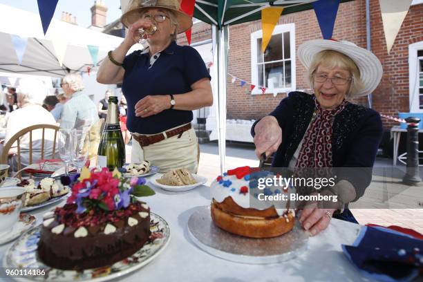 An attendee cuts a cake during a street party to celebrate the wedding of Britain's Prince Harry to Meghan Markle, who will become the Duchess of...