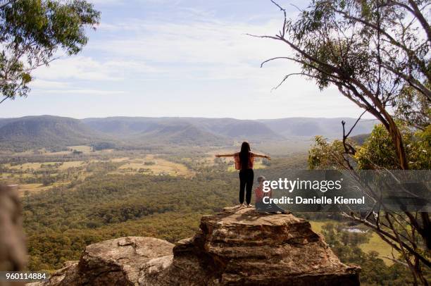 young women standing on cliff in blue mountains - blue mountains australia stock-fotos und bilder