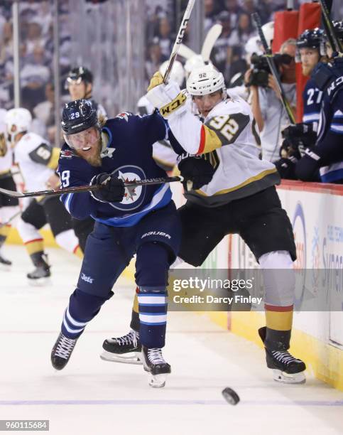Patrik Laine of the Winnipeg Jets and Tomas Nosek of the Vegas Golden Knights battle along the boards as they chase the puck down the ice during...