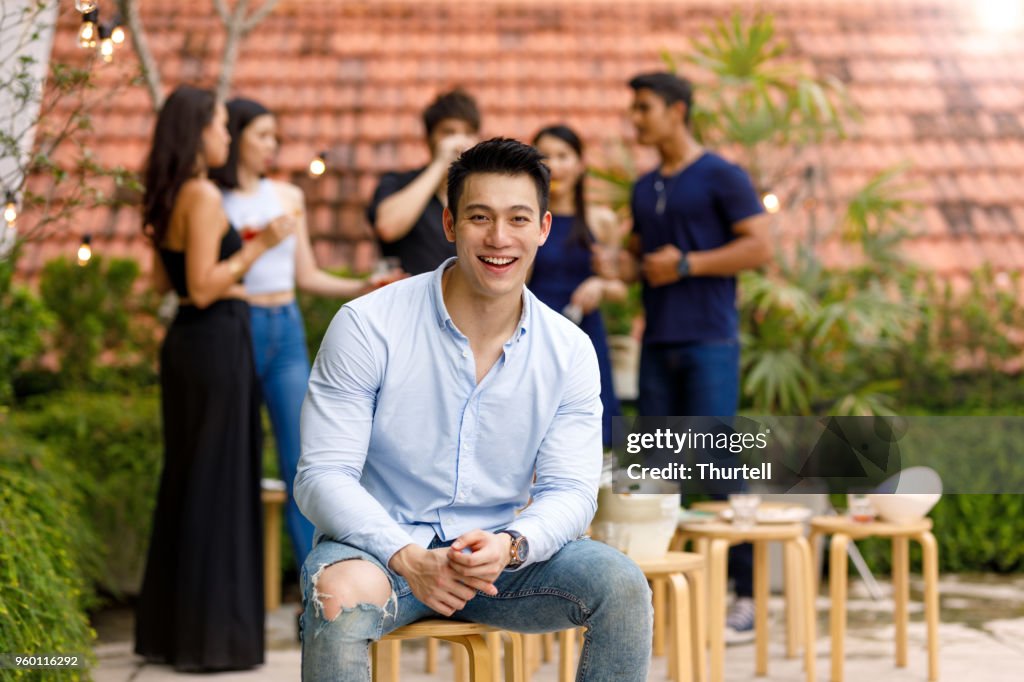 Jonge Aziatische Man genieten van de beste partij buiten dak met vrienden