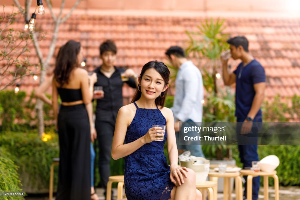 Retrato de joven mujer asiática en la parte superior de techo al aire libre con amigos