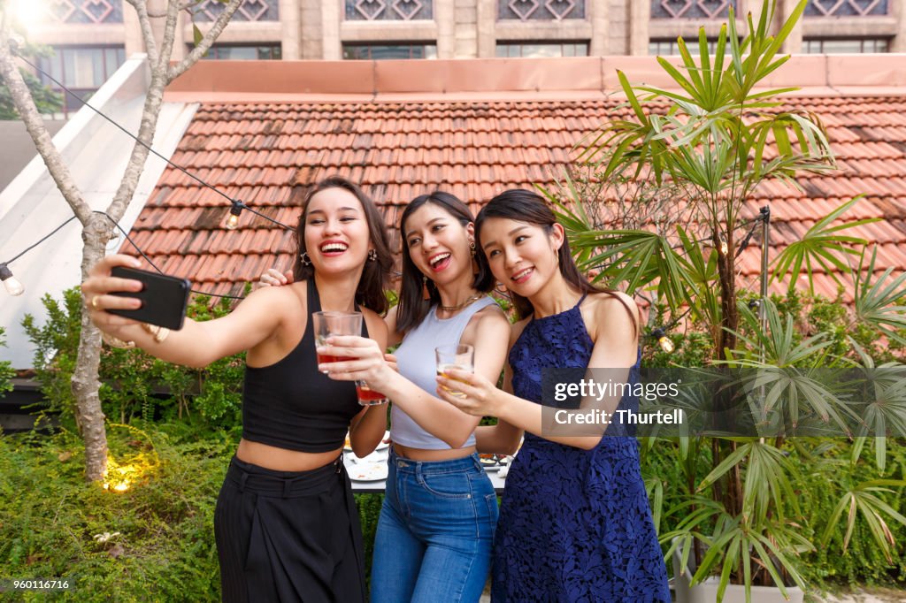 Asiatischen Freundinnen unter Selfies auf Outdoor-Dach Top Party