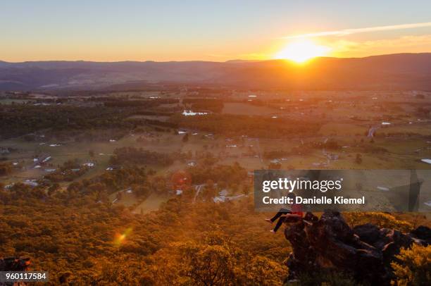 young woman sitting on cliff taking photo at sunset - blue mountains stock pictures, royalty-free photos & images