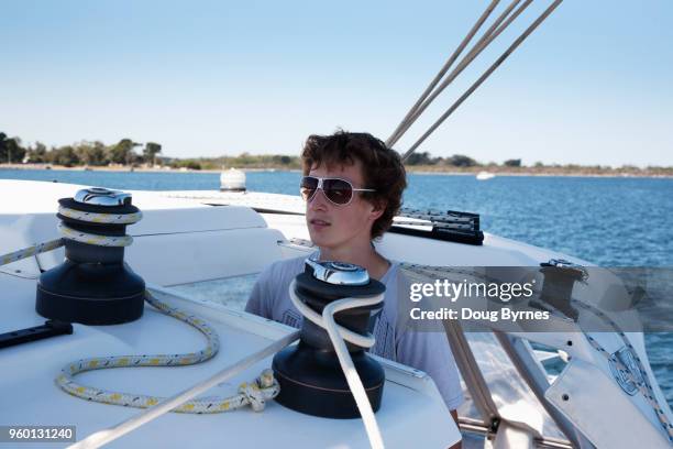 boy steering a yacht - doug byrnes stock-fotos und bilder