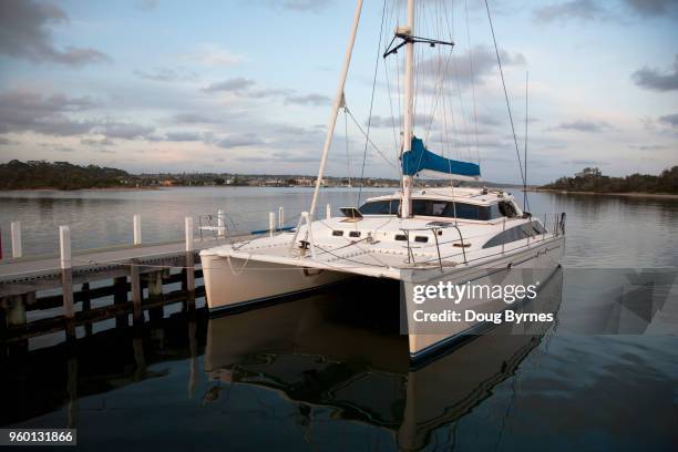 luxury catamaran at dusk - doug byrnes stock-fotos und bilder