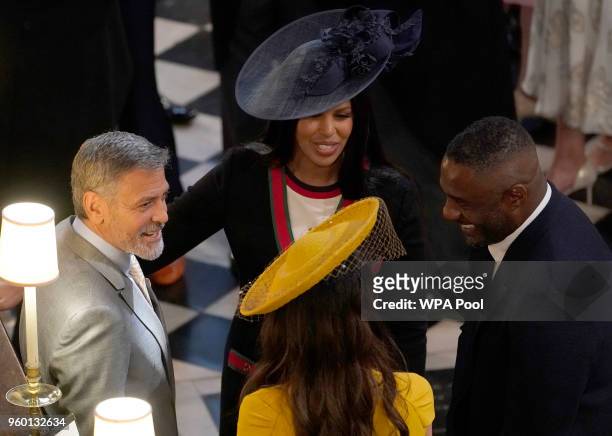 George and Amal Clooney talk to Idris Elba and Sabrina Dhowre in St George's Chapel at Windsor Castle for the wedding of Prince Harry and Meghan...