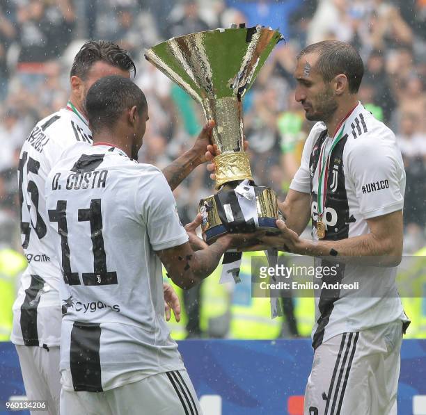 Giorgio Chiellini, Douglas Costa and Andrea Barzagli of Juventus FC celebrate with the trophy after winning the Serie A Championship at the end of...