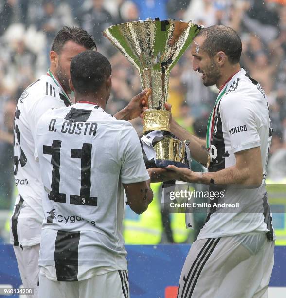 Giorgio Chiellini, Douglas Costa and Andrea Barzagli of Juventus FC celebrate with the trophy after winning the Serie A Championship at the end of...