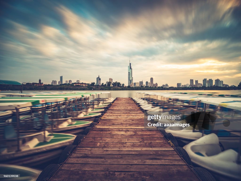 Row of boats moored at xuanwu lakeside with the Zifeng Tower on background