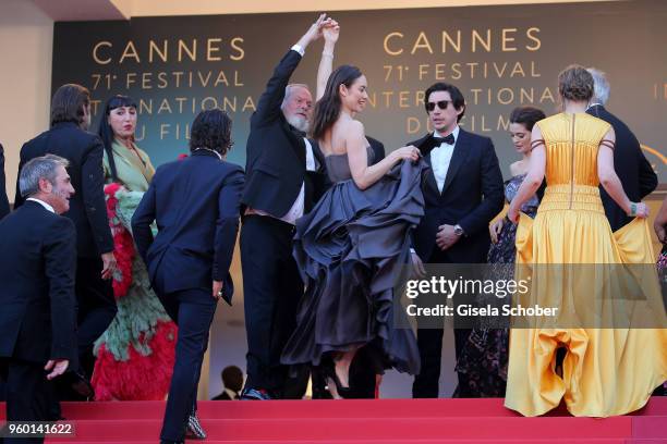 Director Terry Gilliam and actor Olga Kurylenko, dance on the red carpet steps as they attend the Closing Ceremony & screening of "The Man Who Killed...