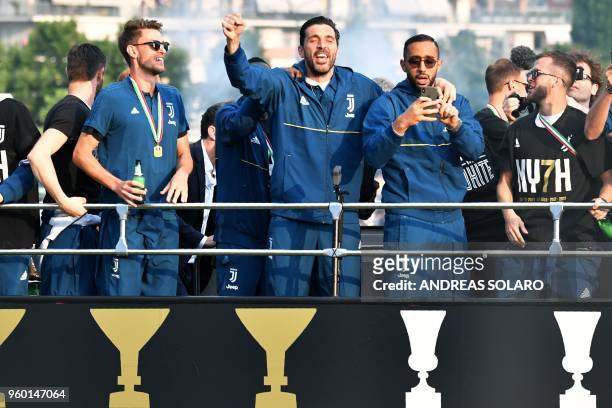 Juventus' players Daniele Rugani , goalkeeper Gianluigi Buffon and defender Medhi Benatia parade with teammates aboard an open-top bus to celebrate...