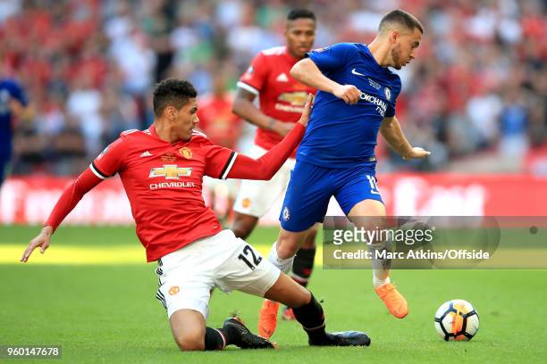 Chris Smalling of Man Utd stretches and Eden Hazard of Chelsea look round for the ball after Smalling knocks it away with a tackle during the...