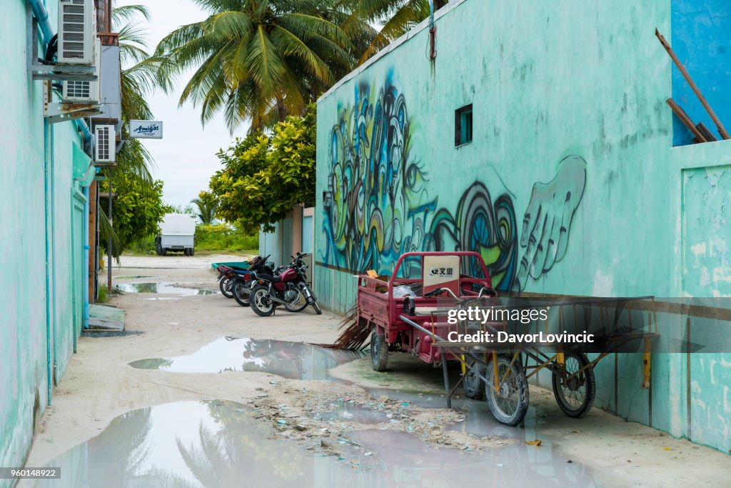 Maafushi Insel Graphit an Nebenstrasse bei Regen im April, Malediven