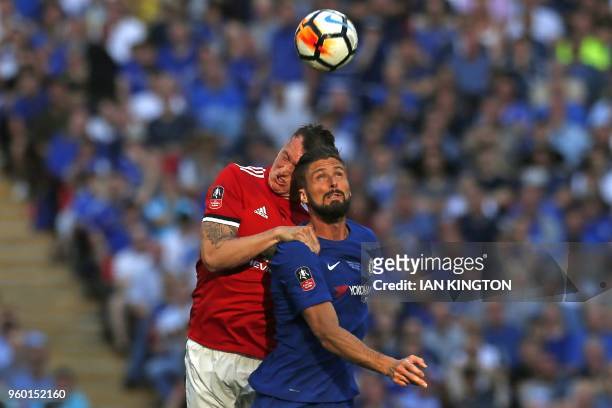 Manchester United's English defender Phil Jones cuts his head in this clash of heads with Chelsea's French striker Olivier Giroud during the English...