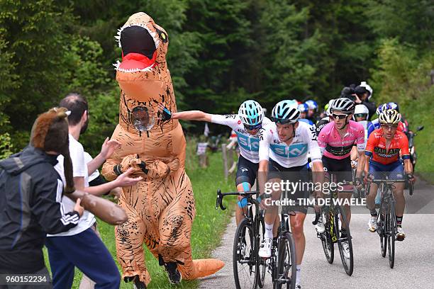 Man dressed with a dinosaur costume runs next to riders Britain's rider of team Sky Christopher Froome and Britain's rider of team Mitchelton-Scott...