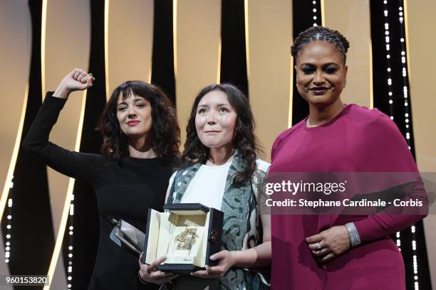 Asia Argento raises her arm as actress Samal Yeslyamova receives the receives the Best Actress award for 'Ayka' as Jury member Ava DuVernay presents...