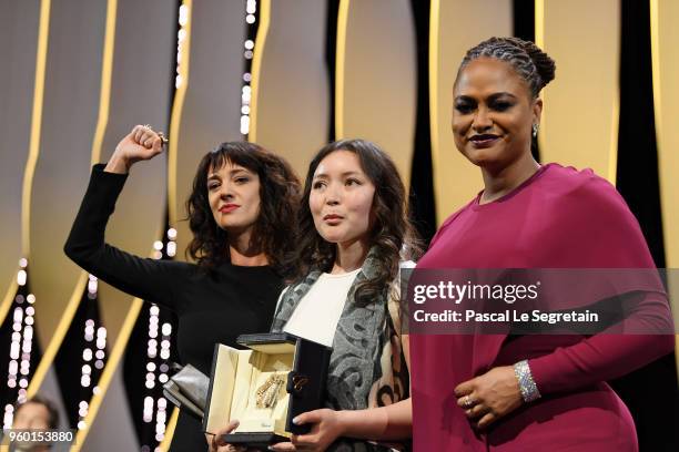 Asia Argento raises her arm as actress Samal Yeslyamova receives the receives the Best Actress award for 'Ayka' as Jury member Ava DuVernay presents...