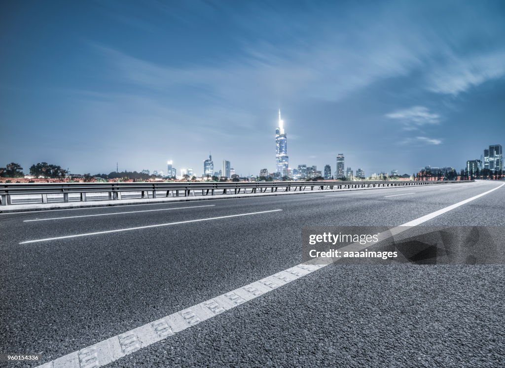 Empty tarmac road with nanjing panoramic skyline on background