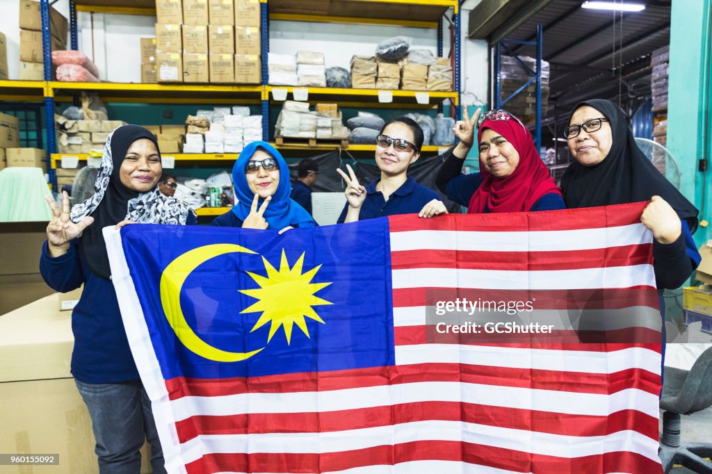 Malayian factory women together behind their flag