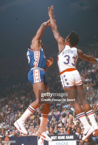 Truck Robinson of the Washington Bullets leaps to defend the pass from George McGinnis of the Philadelphia 76ers during an NBA basketball game circa...