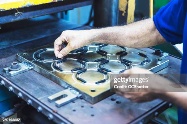 ajouter soigneusement annelets au moule de continuer le traitement des matières premières. - rubber photos et images de collection