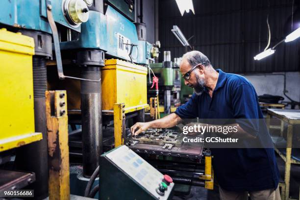 empleado de fábrica trabajando duro completando sus tareas. - molde fotografías e imágenes de stock