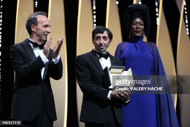 Italian actor Marcello Fonte poses on stage with Italian actor Roberto Benigni and Burundian singer and member of the Feature Film Jury Khadja Nin on...