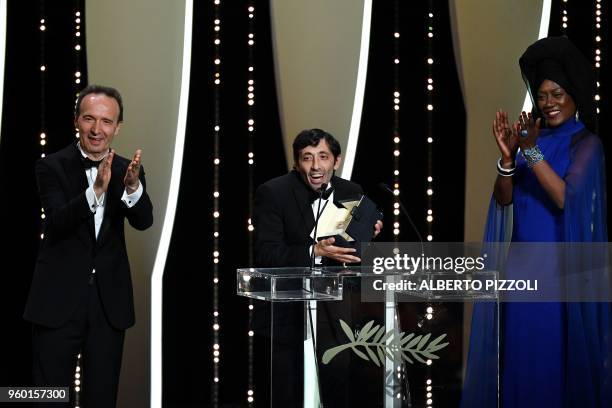 Italian actor Marcello Fonte delivers a speech on stage next to Italian director Roberto Benigni and Burundian singer and member of the Feature Film...